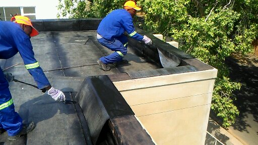 Flat roof waterproofing work in progress at a Sandton townhouse complex by Drytek Waterproofing.