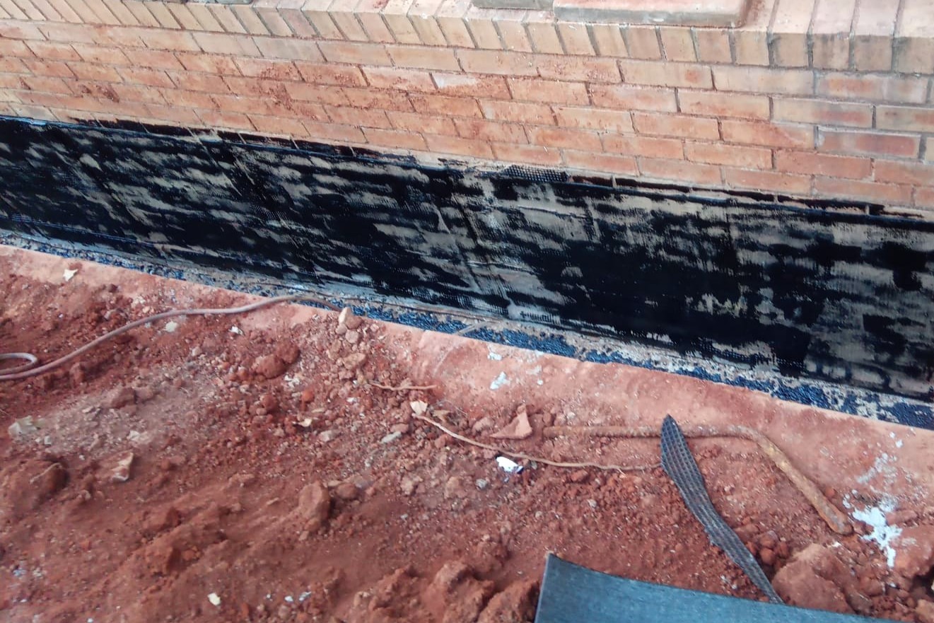 Torch-on waterproofing membrane applied to a foundation wall