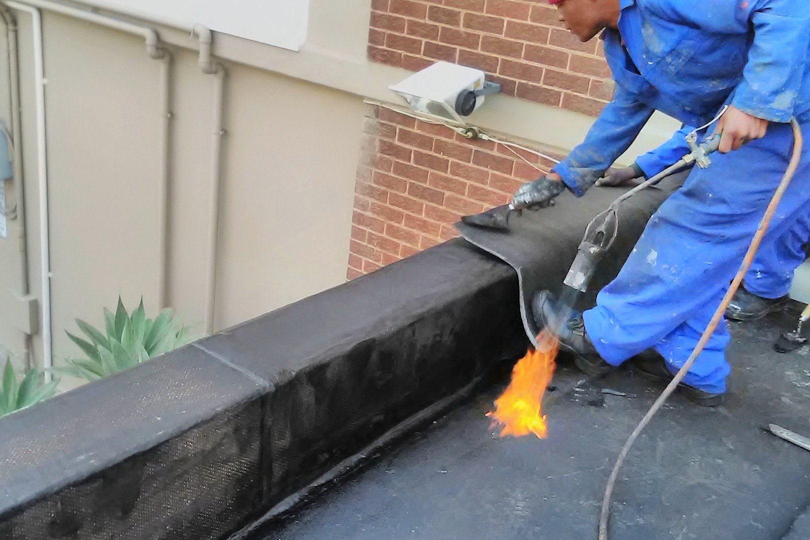Torch-on waterproofing membrane being installed on a flat roof